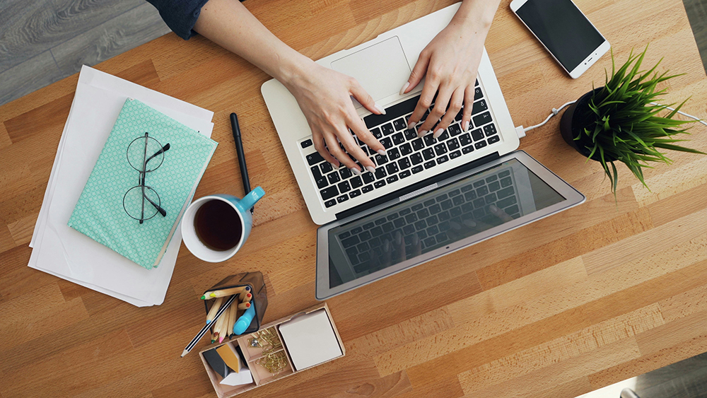 overhead view of laptop at desk - letting employees keep their laptops